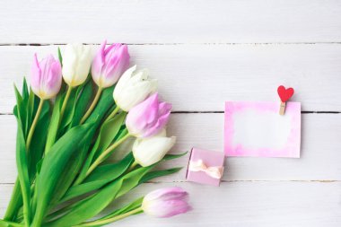 Beyaz ahşap arka planda güzel beyaz ve mor laleler. Bahar. Suluboya kalpli Uluslararası Kadınlar Günü kartı. Sevgililer Günü. Seçici odak.