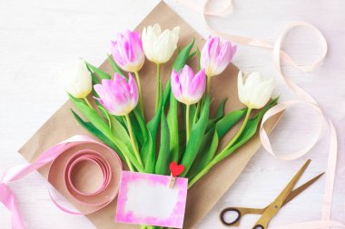 Çiçekçi bir buket yumuşak lale topluyor, seçici bir odak noktası var. Kadınlar Günü, Sevgililer Günü. Anneler Günü