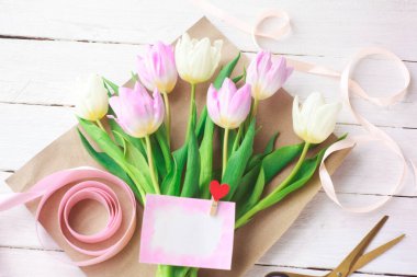 Çiçekçi bir buket yumuşak lale topluyor, seçici bir odak noktası var. Kadınlar Günü, Sevgililer Günü. Anneler Günü