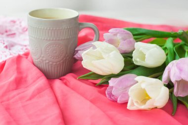 Bir kupa kahveyle bir buket lale ve pembe bir bezin üzerinde kırmızı bir kutuda hediye. Uluslararası Kadınlar Günü, Sevgililer Günü, Anneler Günü. Seçici odak