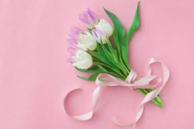 Pembe pastel arka planda bir buket lale. Anneler Günü veya Kadınlar Günü 'nde harika bir bahar kahvaltısı. Düz yatıyordu. Üstten bak. Seçici odak