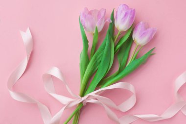 Pembe pastel arka planda bir buket lale. Anneler Günü veya Kadınlar Günü 'nde harika bir bahar kahvaltısı. Düz yatıyordu. Üstten bak. Seçici odak