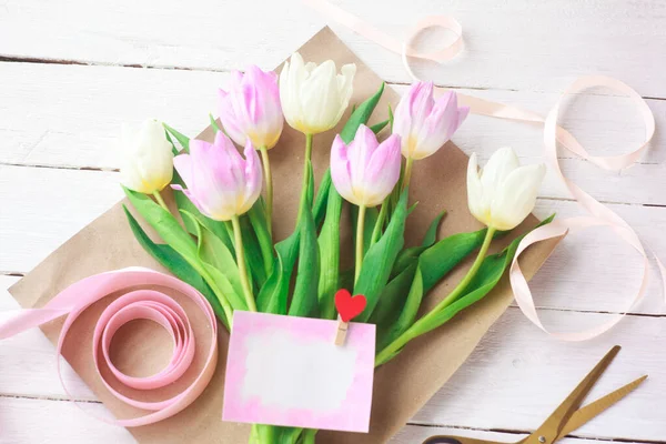 Çiçekçi bir buket yumuşak lale topluyor, seçici bir odak noktası var. Kadınlar Günü, Sevgililer Günü. Anneler Günü