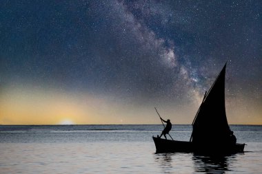 Mauritius adasındaki gölde gün batımında yelkenli.