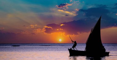 Mauritius adasındaki gölde gün batımında yelkenli.