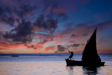 Mauritius adasındaki gölde gün batımında yelkenli.