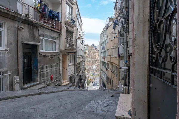 Beyoğlu İstanbul 'da apartman blokları olan dar bir sokak manzarası. Uzun bir yokuş aşağı, sağdaki ve soldaki binaları gösteriyor.