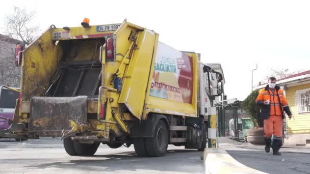 Eminonu, Istanbul, Turecko - 02.18.2021: Žlutý komunální popelářský vůz zaparkovaný v autobusovém depu Eminonu a komunálních zaměstnanců, kteří si dávají pauzu a jdou pít kávu ve vysokém rozlišení 4K — Stock video