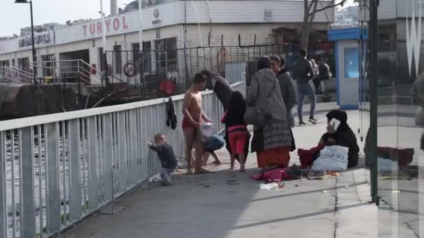 Eminonu, Istambul, Turquia - 02.18.2021: tiro médio de uma família de refugiados enquanto as crianças se vestem e a mãe fala com telefone 4K de alta resolução — Vídeo de Stock