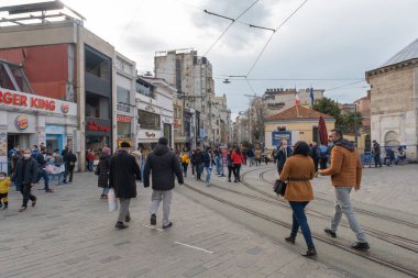 Beyoğlu, İstanbul, Türkiye - 02.17.2021: Taksim 'deki ünlü İstiklal caddesinin girişi ve renkli maskeli insanlar fotokopi alanı ile etrafta dolaşıyorlar