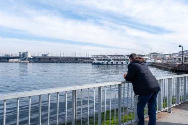 Eminonu, İstanbul, Türkiye - 02.18.2021: Galata Köprüsü 'nün deniz ve manzarasına bakan bir adam ve fotokopi alanı olan gemiler