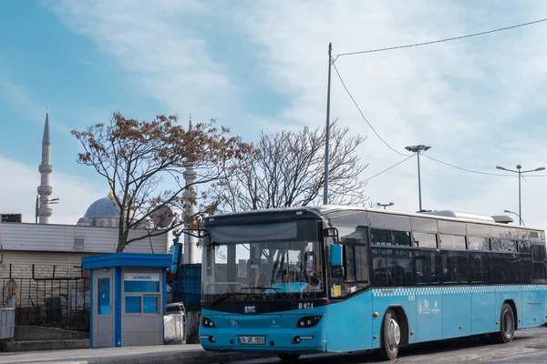 Eminonu, İstanbul, Türkiye - 02.18.2021: üzerinde fotokopi alanı bulunan cami minareleri ve istasyon önündeki otobüs durağına park etmiş mavi belediye otobüsünün önü