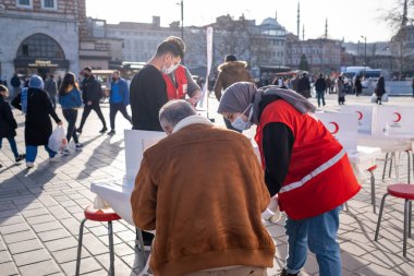 Eminonu, İstanbul, Türkiye - 02.26.2021: Türk Kızılayı 'nın orta boy kadın çalışanı kan bağışı gönüllüsüne yardım etti