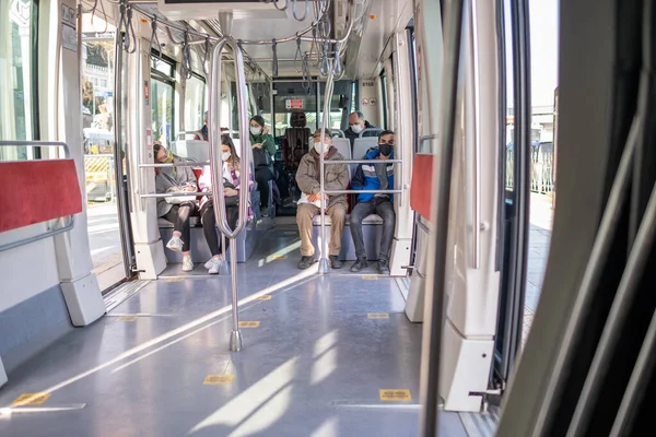 Kabatas, İstanbul, Türkiye - 02.26.2021: maskeli yolcular karantina günlerinde park halindeki Türk tramvayının tramvay koltuklarında oturuyorlar