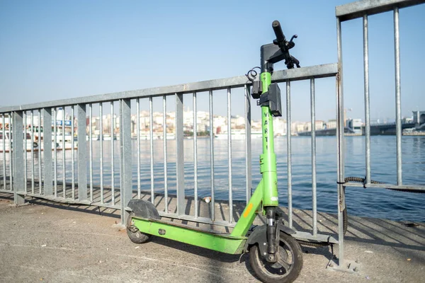 Eminonu, İstanbul, Türkiye - 02.27.2021: Marmara Denizi yakınlarında park etmiş yeşil scooter, Marti (Martı) adlı elektrikli scooter kiralama şirketine ait.