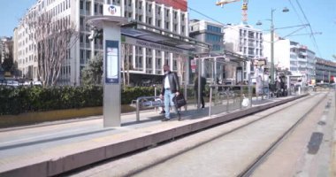 Beyoğlu, İstanbul, Türkiye - 03.17.2021: Gün ışığında tramvay istasyonuna gelmek için bekleyen çok sayıda yolcu karantina günlerinde geliyor