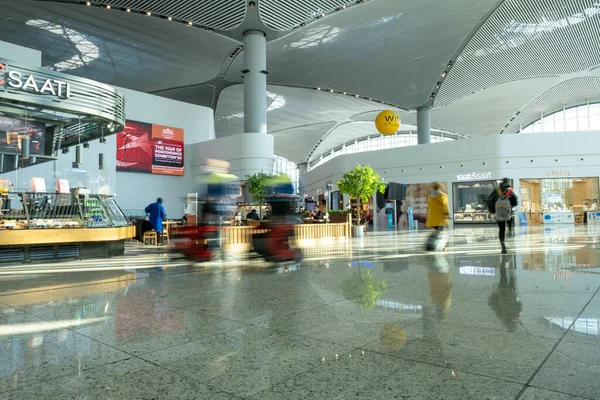 Arnavutkoy, İstanbul, Türkiye - 03.08.2021: İstanbul Havalimanı 'nın büyük salonu ve çevresindeki dükkanlar ve yolcular ve bina personeli düşük panjurlu iç görüşe sahip