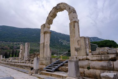 Selcuk, İzmir, Türkiye - 03.09.2021: Ticari Agora kapısı ve Doğu Akdeniz bölgesindeki tarihi Roma arkeoloji sahaları olan Efes harabelerinde ticaret malları ve köleler için pazar meydanı