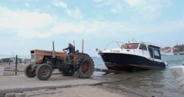 Foca, İzmir, Türkiye - 03.09.2021: Foca kıyısındaki bir traktörün aracıyla denizden eski bir tekne çıkarma yöntemi