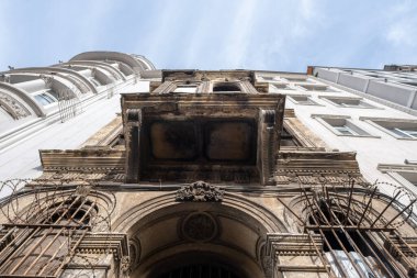 Taksim, İstanbul, Türkiye - 03.12.2021: mavi gökyüzü altında eski harabe tarihi bir bina ve aralarında yeni modern binalar düşük açılı görünüm