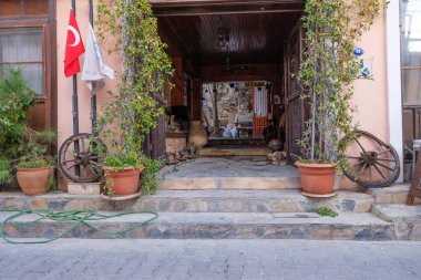 Urla, İzmir, Türkiye - 03.08.2021: tarihi kapısı ve Türk bayrağıyla küçük bir pansiyon ve otel girişi