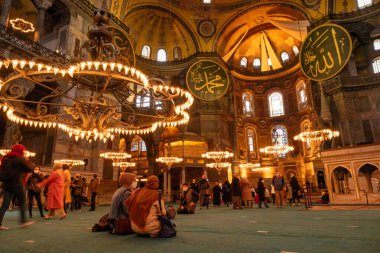 Fatih, İstanbul, Türkiye - 04.05.2021: Türk ve yabancı ziyaretçiler yakın tarihte müzeden dönüştürülmüş Ayasofya Camii 'nde oturuyor, geziyor ve fotoğraf çekiyor