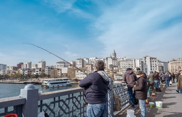 Eminonu, İstanbul, Türkiye - 04.13.2021: Galata Köprüsü 'nde balıkçılık yapan ve olta tutan ve temiz havada balık bekleyen bir çok Türk vatandaşı