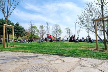 Kadıköy, İstanbul, Türkiye - 04.29.2021: Karantina zamanından önce Moda Halk Parkı 'nın alçak açısı ve açık bir ilkbahar gününde fotokopi alanı ile çimlerin üzerinde oturup uzanan çok sayıda insan