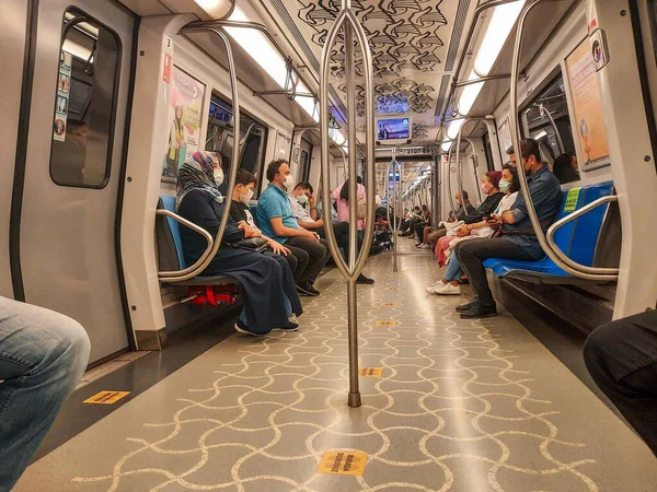 Kadıköy, İstanbul, Türkiye - 06.08.2021: Korumalı maskeli Türkler metro koltuklarında oturuyor ve yeraltı korona virüsü önleme kavramında fotokopi alanı ile seyahat ediyorlar