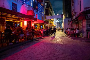 Beyoğlu, İstanbul, Türkiye - 07.07.2021: salgın önlemlerinin gevşetildiği bazı barlar disko restoranları ve gece kulüpleriyle eğlence sokağının pembe ve kırmızı renkli renkleri
