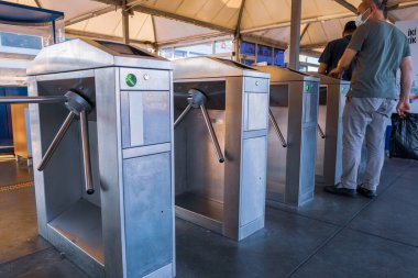 Fatih, İstanbul, Türkiye - 07.21.2021: Eminonu Kadıköy feribot terminali ve yolcu gemilerinin ulaşım limanı deniz seyahati kavramları için yaz günü bilet engellerini aşan insanlar