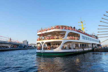 Fatih, İstanbul, Türkiye - 07.16.2021: yolcu gemisi bir yaz günü Galata Köprüsü ile birlikte Eminonu-Kadikoy feribot terminaline gitmek üzere.