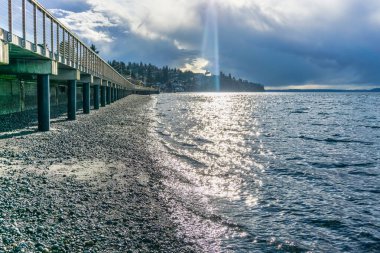 Redondo Beach, Washington 'daki Puget Sound' da ışık huzmeleri parlıyor..