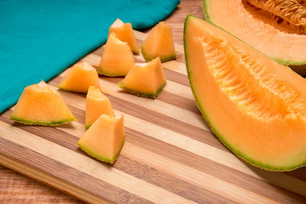 Melão Melão Cantaloupe Cortado Pequenos Pedaços Uma Placa Corte Bambu — Fotografia de Stock