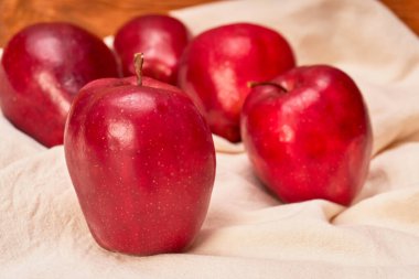 Bir grup kırmızı elma bej bir tuval ve ahşap arka planda. sağlıklı yeme kavramı.