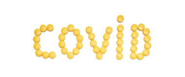 Sarı ağrı kesici haplar (ibuprofen) beyaz arka planda covid (sars-cov-2) kelimesini oluşturur. Reklam için ideal..
