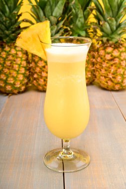 Kasırga bardağında üzerinde bir parça ananas olan iki pina colada. Beyaz koşu, hindistan cevizi kreması, ananas suyu ve buzdan yapılmış. Sarı popolu ve taze ananaslı. Karayip alkollü içeceği.