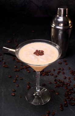 İrlanda kremalı kokteyl ve kahve bardağında kahve çekirdekleri ve siyah mermer bir yüzey ve kahve çekirdekleri. Reklam için fotokopi alanı olan siyah bir arkaplan. görünümü kapat