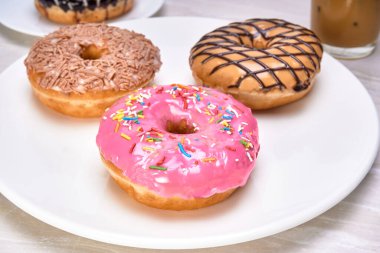 Beyaz mermer bir yüzey üzerinde beyaz bir tabakta 3 tane jöleli çörek, çilekli (çörek Homer), çikolata ve akçaağaç. yakın çekim görünümünde