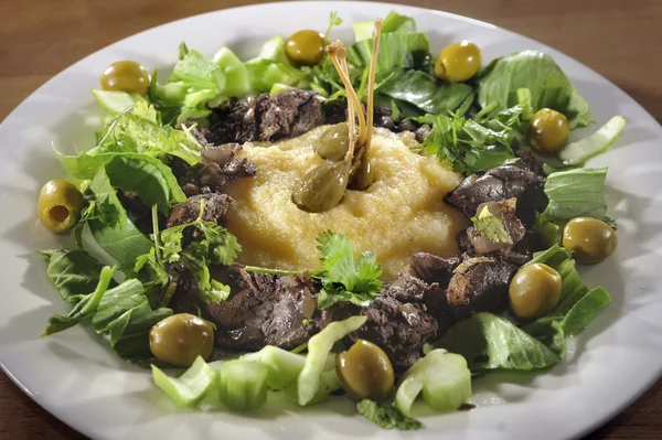 Chicken liver with polenta, caperberries, herbs and olives — Stock Photo, Image