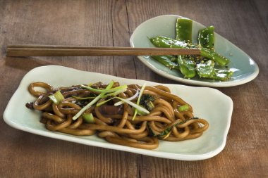 Stir fried udon noodles with bok choy, oyster mushroom and scallions served with stir fried green beans clipart