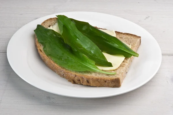 Wild garlic leaves (bear's garlic) on sourdough bread — Stock Photo, Image