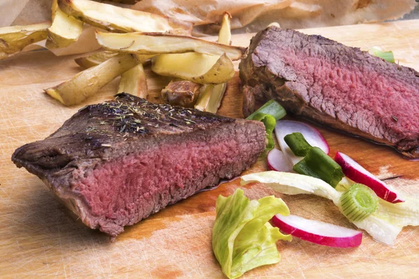 Bife grelhado médio raro com batatas assadas e sal — Fotografia de Stock