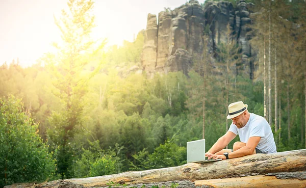 Successful freelancer businessman with a laptop in the mountains. High quality photo