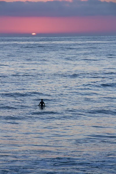 Günbatımında sörfçü