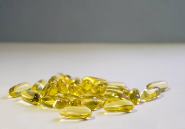 Sarı kapsüller ışık arka planına saçılmıştır..