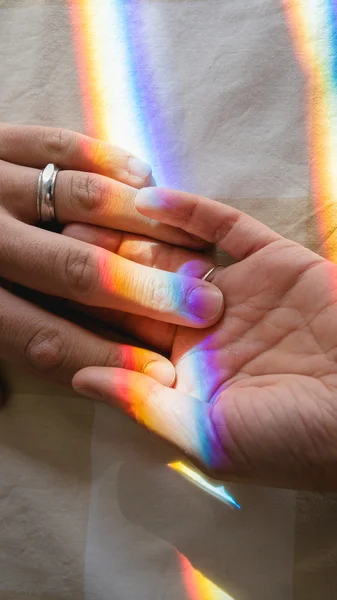 Mano nella mano con l'arcobaleno Foto Stock