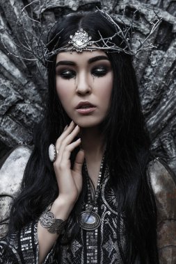 Zırhlı güzel savaşçı kara cadı prenses. Fantezi şövalyesi siyah saçlı çelenk giyen kadın. Peri masalı gotik kraliçesi.