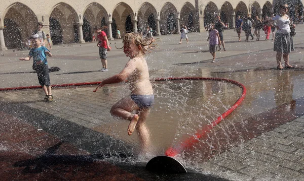 Yuoth buscando escapar del calor del verano en la Plaza Principal en Cracovia, Polonia —  Fotos de Stock