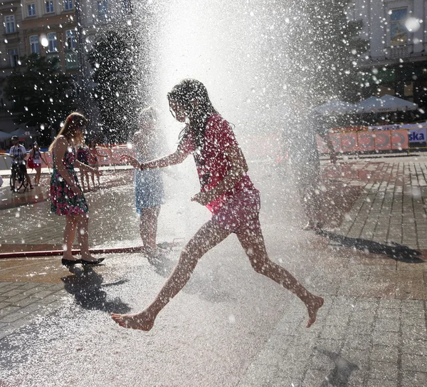 Yuoth buscando escapar del calor del verano en la Plaza Principal en Cracovia, Polonia —  Fotos de Stock